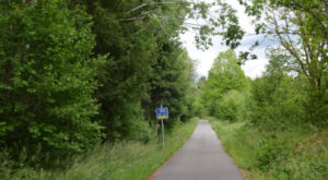 Vennbahn cycle route: greenway distance sign post "100km from Aachen" with local emergency call numbers