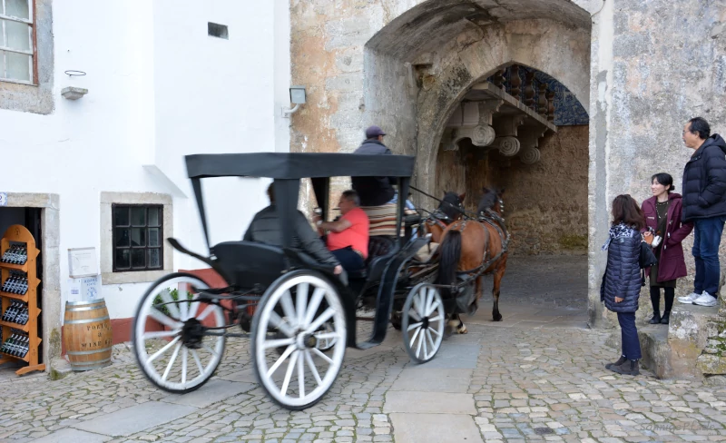 Charrete - horse drawn carriage for sightseeing at the town gate of Óbidos town wall