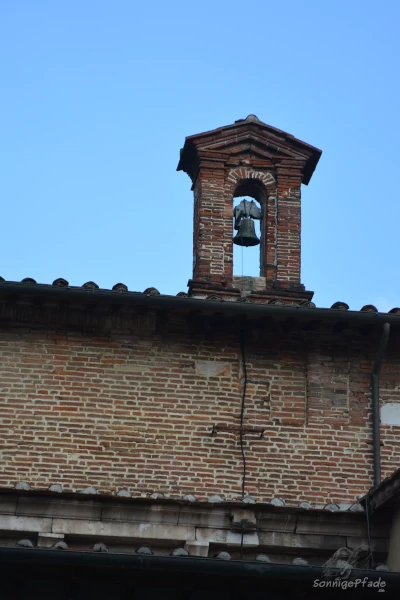 Eine Glocke  in einem gemauerten Joch auf dem Dach