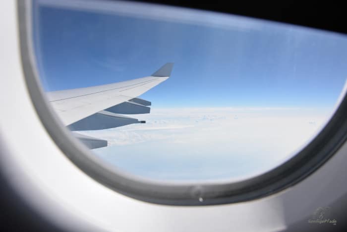 "Über den Wolken" - Blick aus dem Fenster eines Flugzeugs während des Fluges