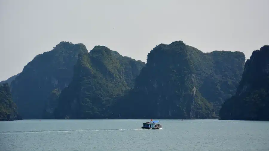 Kleines Motorboot vor Felsenkulisse der Ha Long Bucht